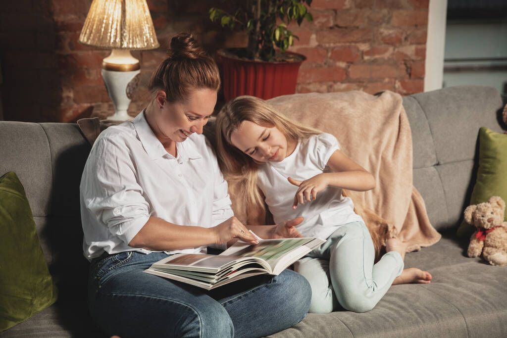 Madre e hija durante el auto-aislamiento en casa mientras están en cuarentena, tiempo familiar acogedor y confort
 - Foto, Imagen
