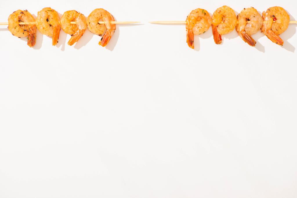 vista superior de deliciosos langostinos fritos en brochetas sobre fondo blanco
 - Foto, imagen