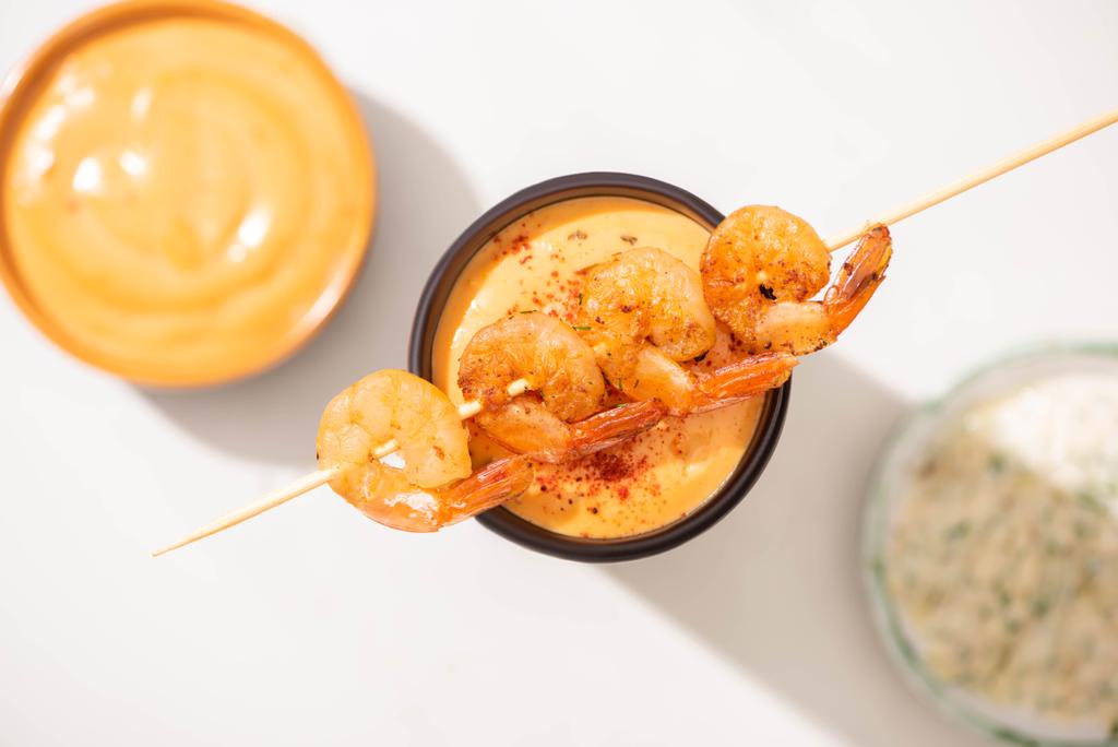 selective focus of delicious fried prawns on skewer with sauce on white background - Photo, Image