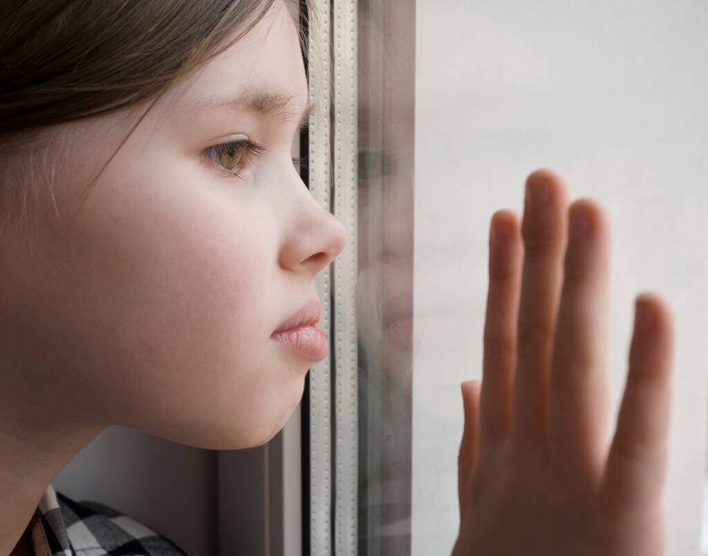 Girl is looking through window. Sad concept. - Photo, Image