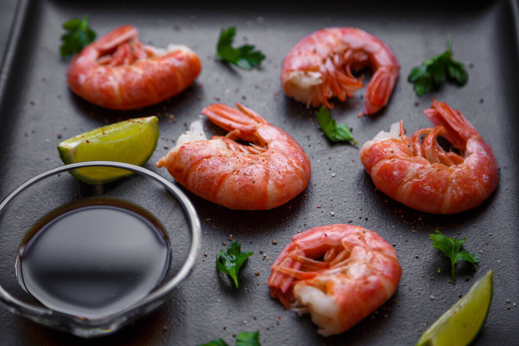 Grilled prawns with pepper parsley and lime on a dark background - Photo, Image