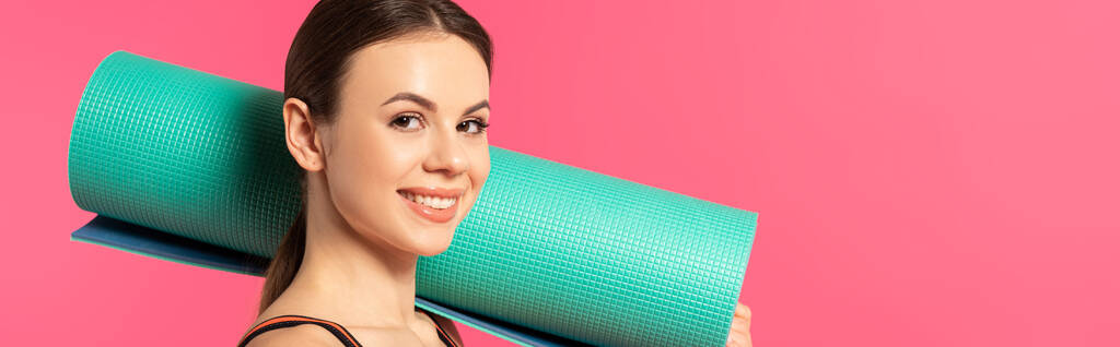 cultivo panorámico de deportista feliz celebración de la alfombra de fitness aislado en rosa
  - Foto, imagen