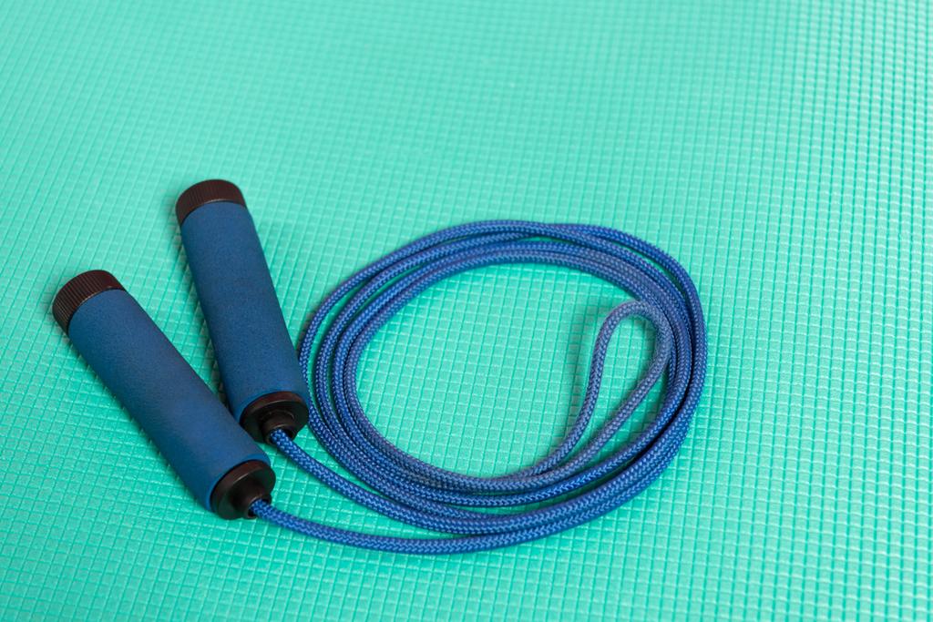 cuerda de salto azul en la estera de fitness turquesa
 - Foto, imagen