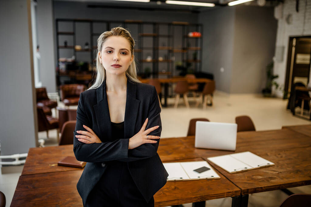 Portrait of a successful young business lady in a classic suit standing in the office - Photo, Image