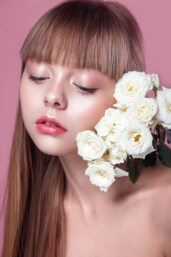 Женщина на розовом фоне студии с цветами розы
 - Фото, изображение