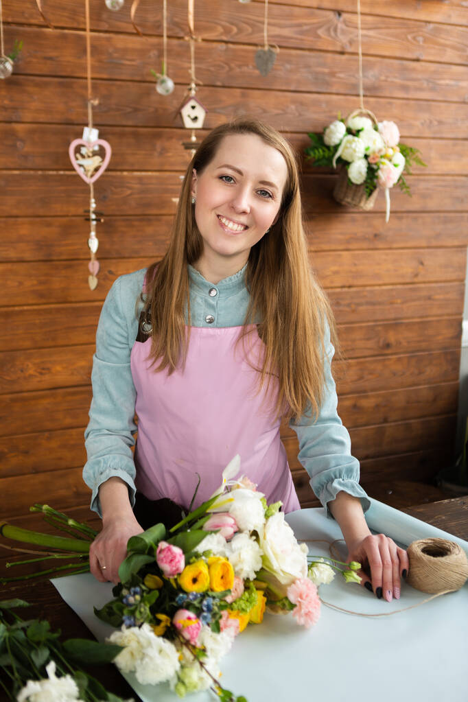 花屋の女の子は大きな美しい花束を収集します。花屋のコンセプト、ビジネスコンセプト、ギフト、驚き、牡丹、バラ、カーネーション。中小企業 - 写真・画像