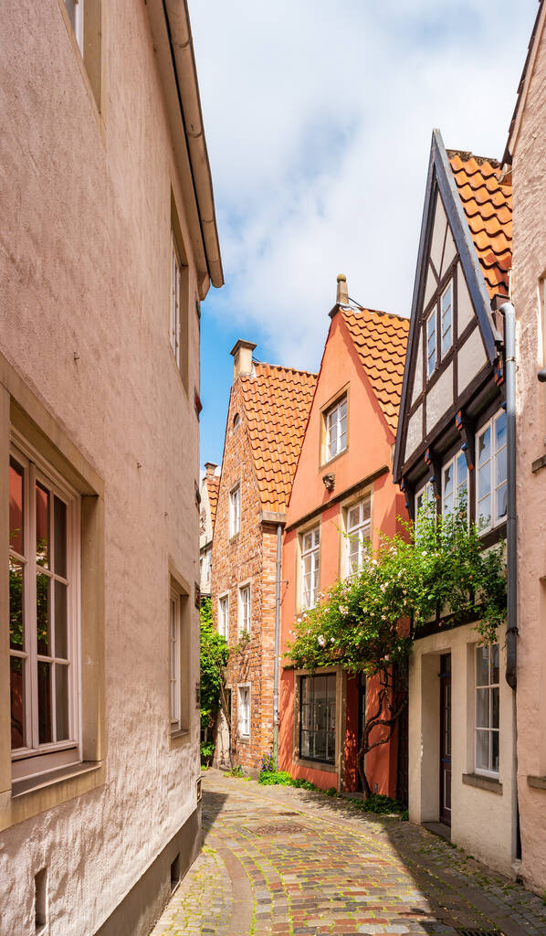 ドイツのブレーメン。歴史あるシュノーア地区の古い町の狭い通り。夏の日に太陽に照らされた小さな中世の家. - 写真・画像