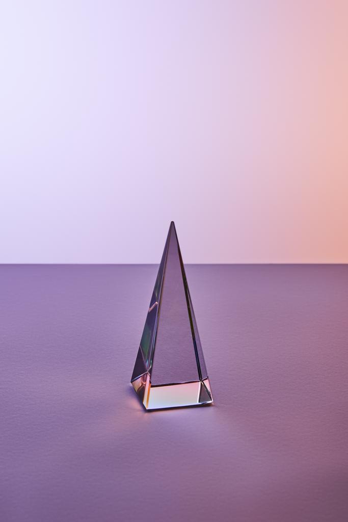 Kristall transparente Pyramide mit Lichtreflexion auf violettem und violettem Hintergrund - Foto, Bild