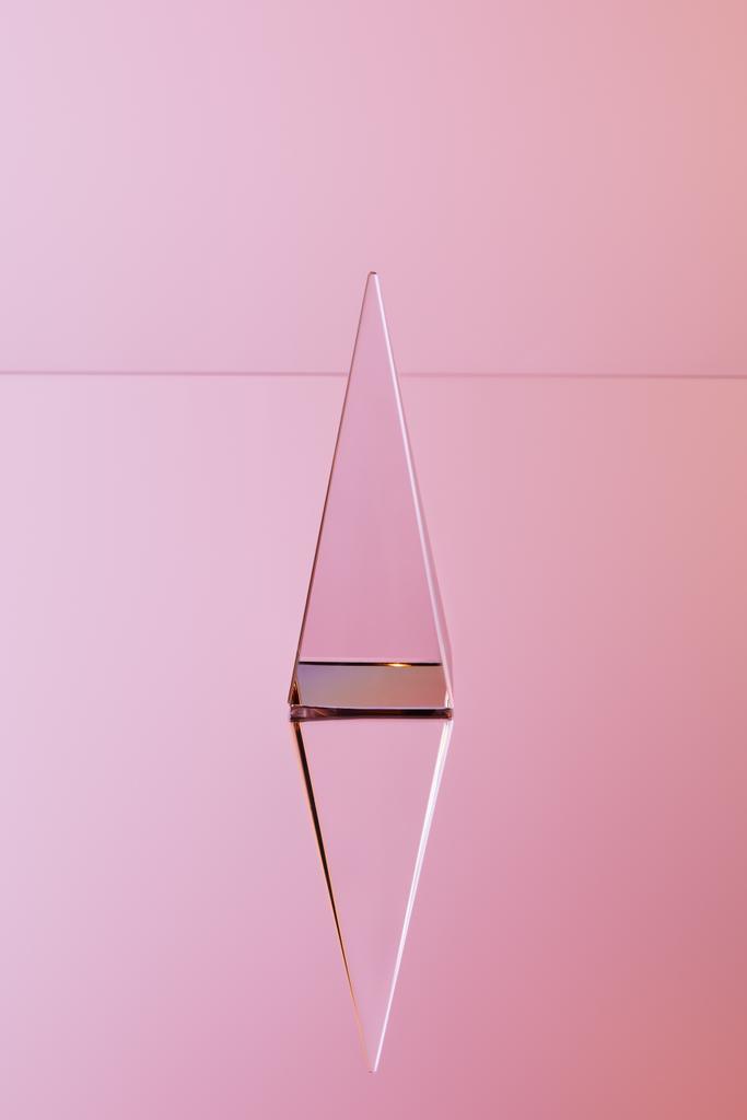 pyramide transparente cristal avec réflexion sur fond rose
 - Photo, image