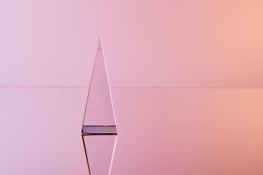 Kristall transparente Pyramide mit Reflexion auf rosa Hintergrund - Foto, Bild