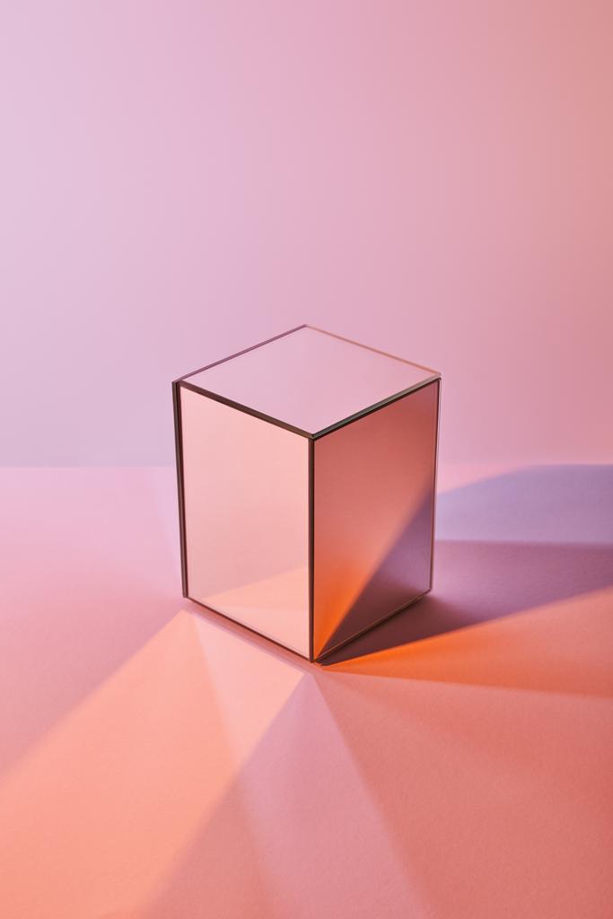 kubus met lichtreflectie op het oppervlak op een paarse en roze achtergrond - Foto, afbeelding