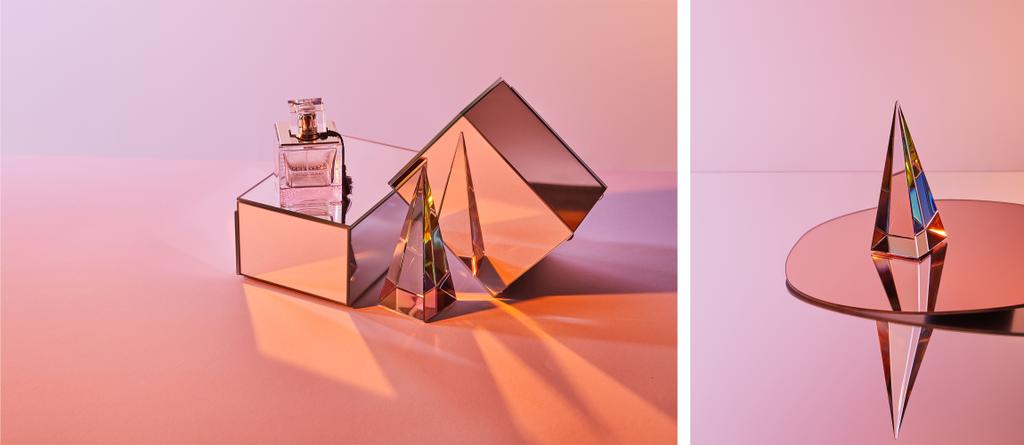 kolaż krystalicznie przezroczystej piramidy w pobliżu butelki perfum na pudełku i okrągłe lustro na różowym tle - Zdjęcie, obraz