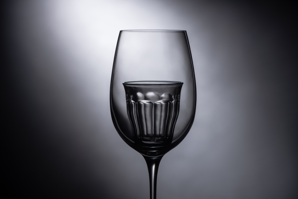 vaso de chupito vacío en copa de vino sobre fondo oscuro
 - Foto, imagen