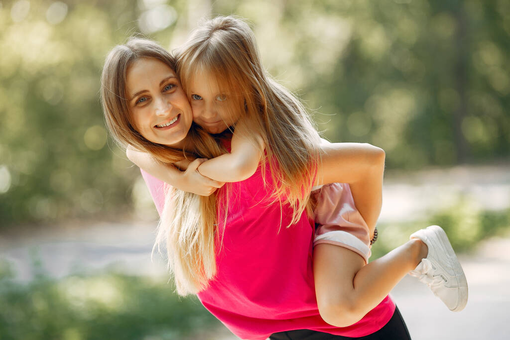 Mutter mit Tochter spielt im Sommerpark - Foto, Bild