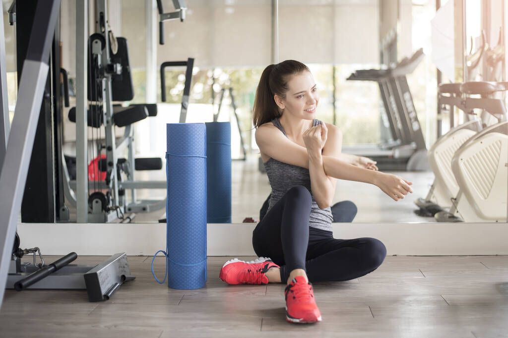 Hübsche junge sportliche Frau wärmt sich im Fitnessstudio auf, Gesunder Lebensstil - Foto, Bild