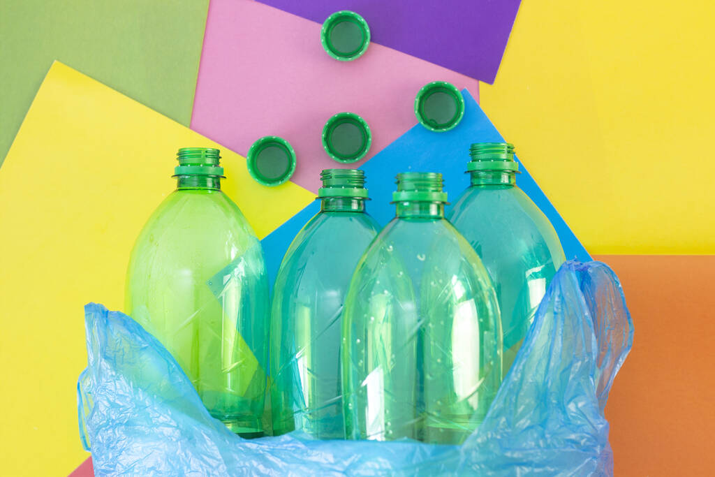 Odpadky, plastové láhve v igelitovém sáčku, na barevném abstraktním pozadí. Ekologie a znečištění planety Země. Řazení odpadků. - Fotografie, Obrázek