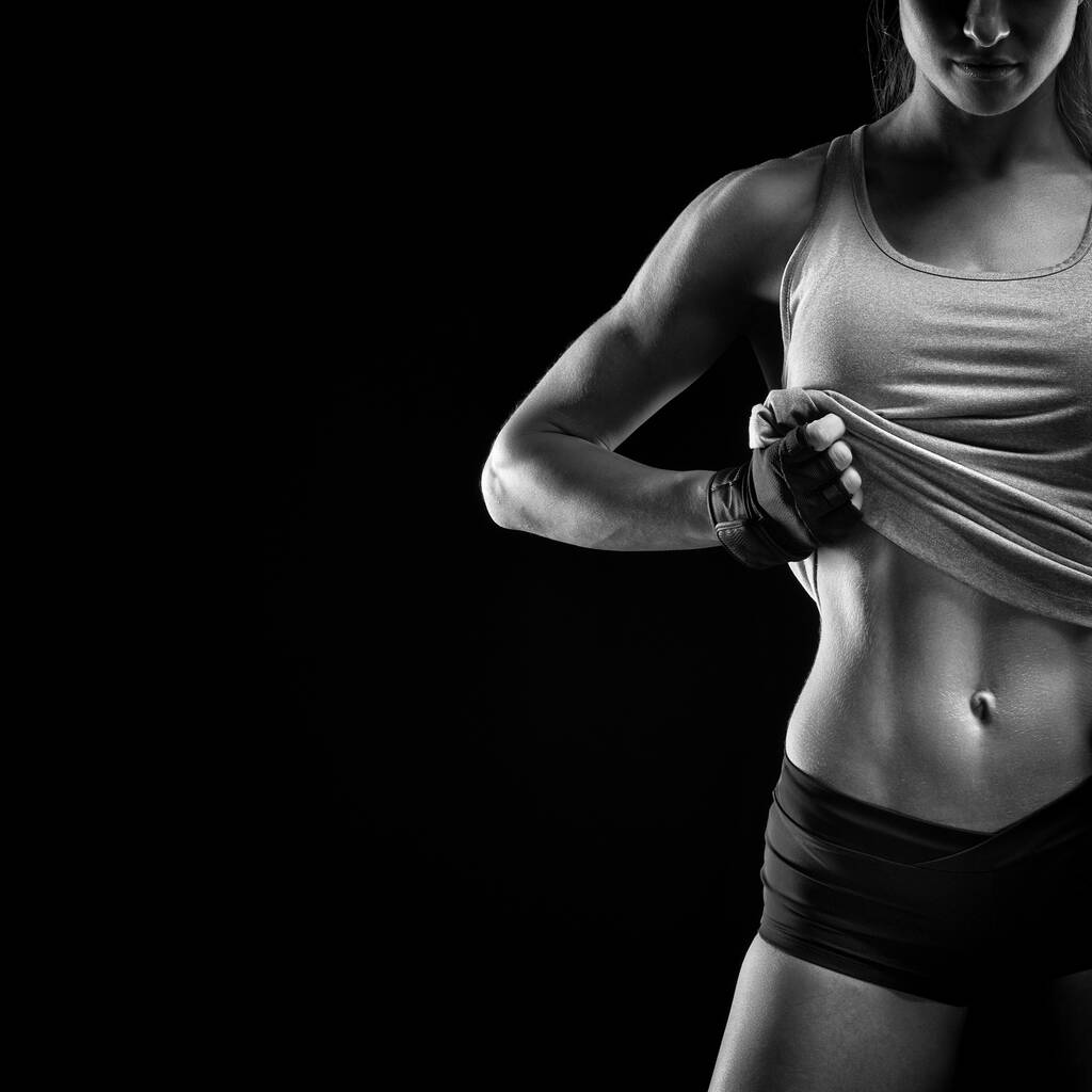 Fitness sportieve vrouw tonen haar goed getraind lichaam en buikspieren - Foto, afbeelding