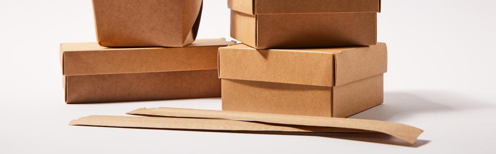 immagine orizzontale di bacchette in confezione di carta vicino a scatole da asporto con cibo cinese su bianco
  - Foto, immagini