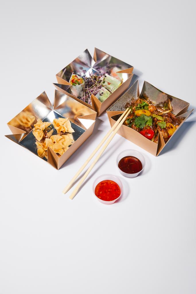 箸やソースの近くに中華料理を白で用意した持ち帰り用の箱  - 写真・画像
