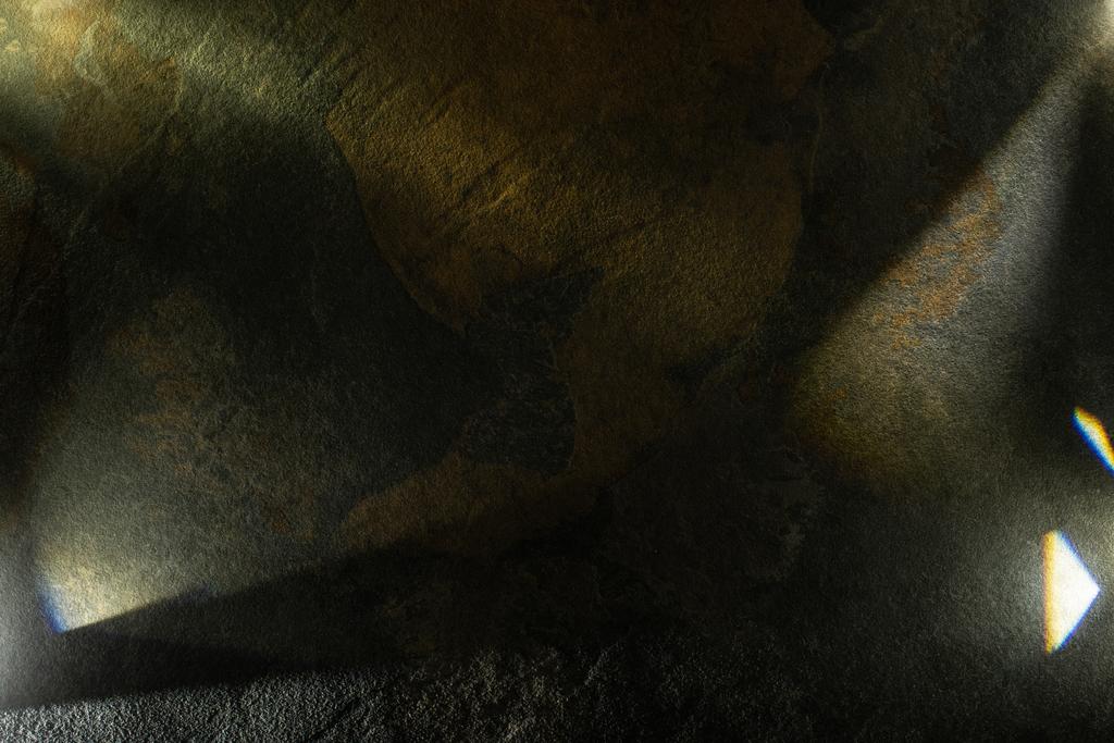 licht prisma met balken op donkere stenen textuur achtergrond - Foto, afbeelding