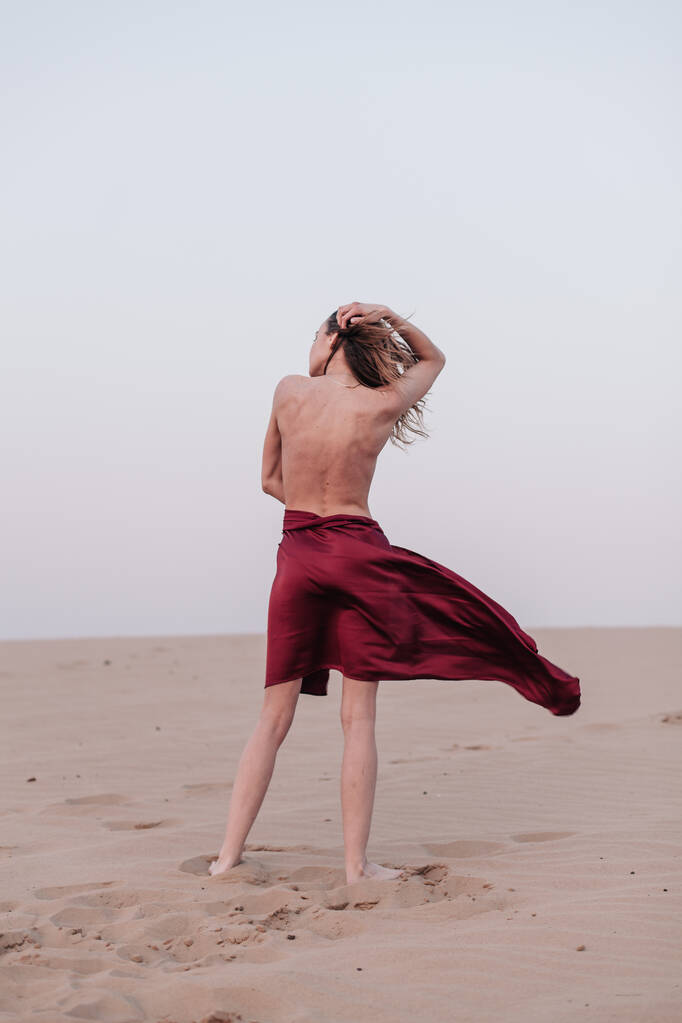 Dívka s látkou stojí ve větru v poušti - Fotografie, Obrázek