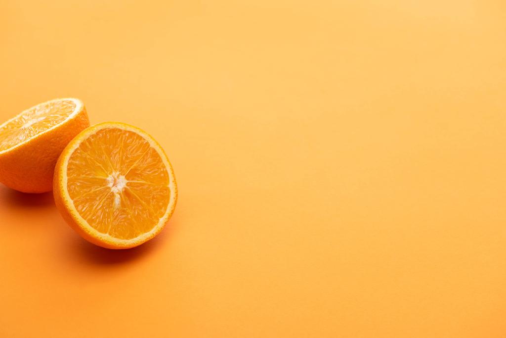 zralé lahodné oranžové půlky na barevném pozadí - Fotografie, Obrázek