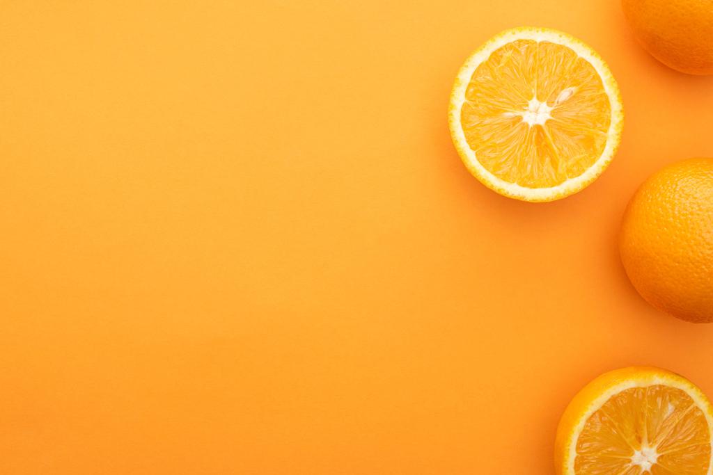 vista superior de jugosas naranjas enteras y rebanadas sobre un fondo colorido
 - Foto, Imagen