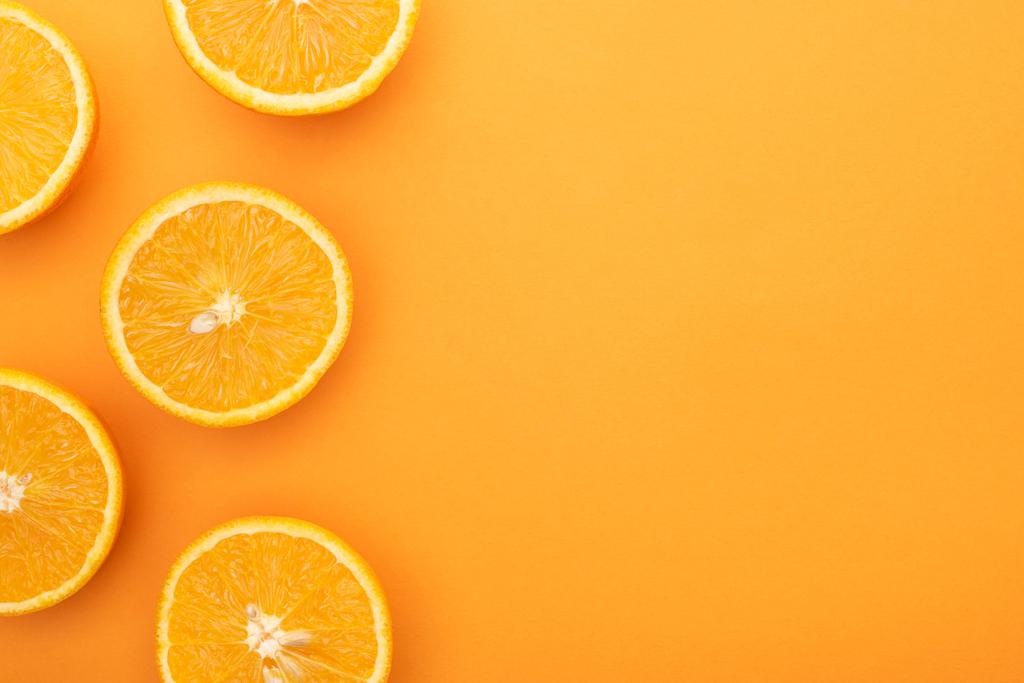 vista superior de las rebanadas de naranja jugosas maduras sobre un fondo colorido con espacio para copiar
 - Foto, Imagen
