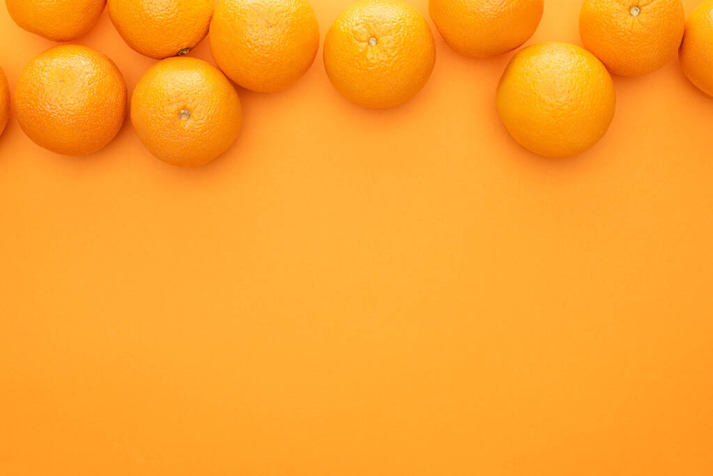 コピースペースのあるカラフルな背景に熟したジューシーな全体のオレンジのトップビュー - 写真・画像