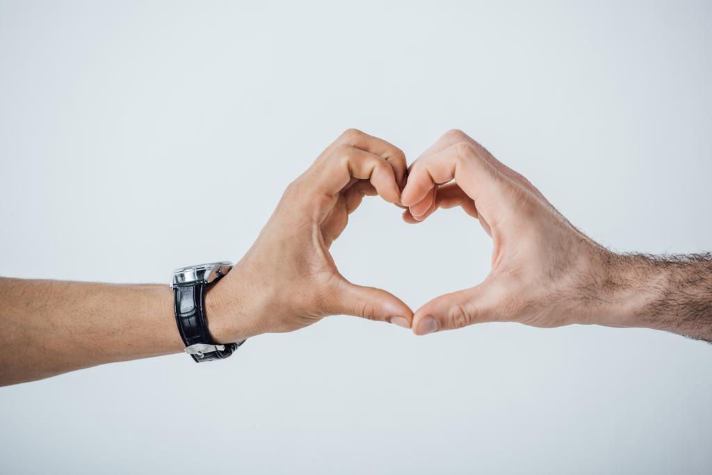 Ausgeschnittene Ansicht von Männerhänden, die Herzzeichen isoliert auf grau zeigen  - Foto, Bild