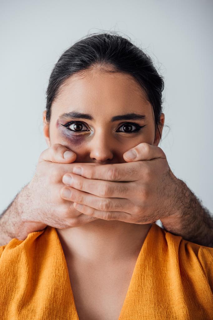 Mani maschili che coprono la bocca alla donna indiana con lividi isolati su grigio
 - Foto, immagini
