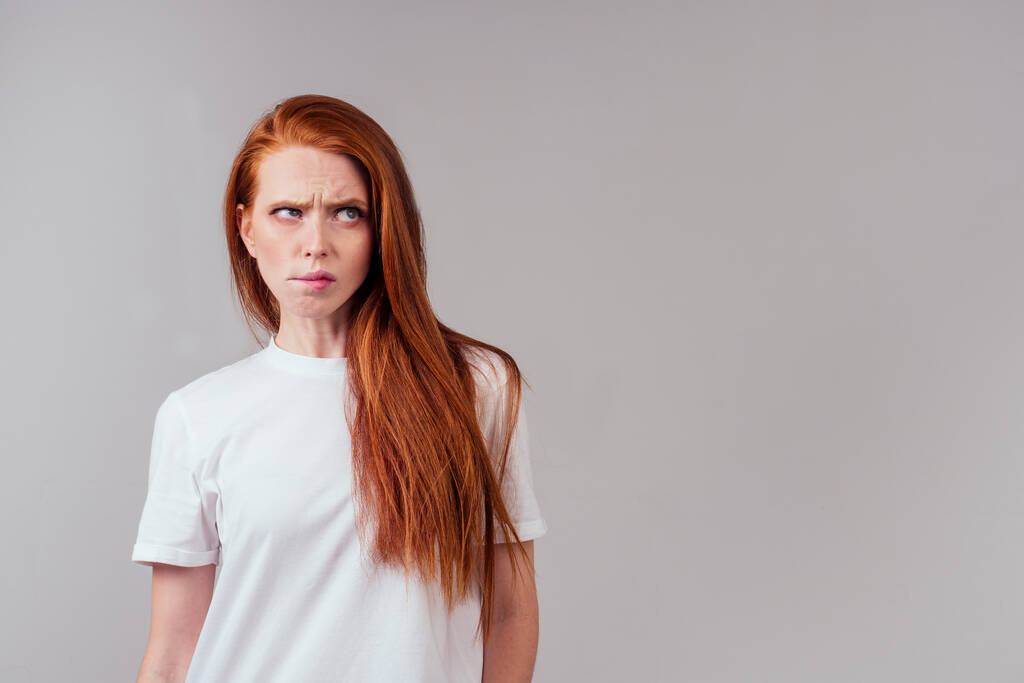 roodharige vrouw gevoel boos en irritatie studio achtergrond - Foto, afbeelding