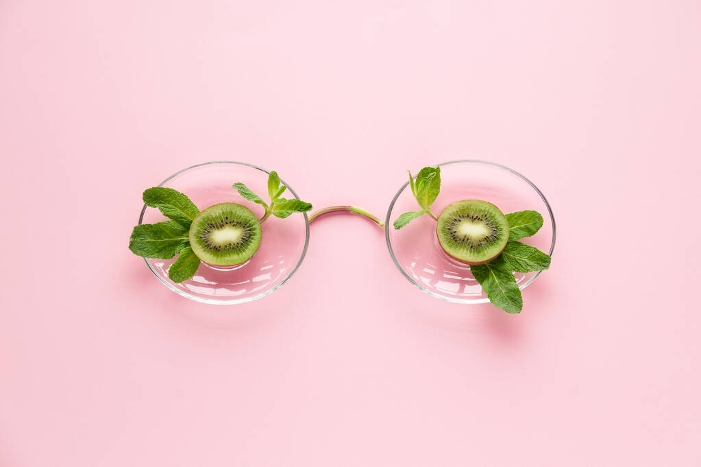 Sommerbrille aus Kiwi-Früchten und Minze auf rosa Hintergrund - Foto, Bild