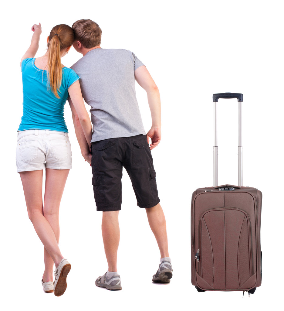 jeune couple voyageant avec suitcas et pointant à mur - Photo, image