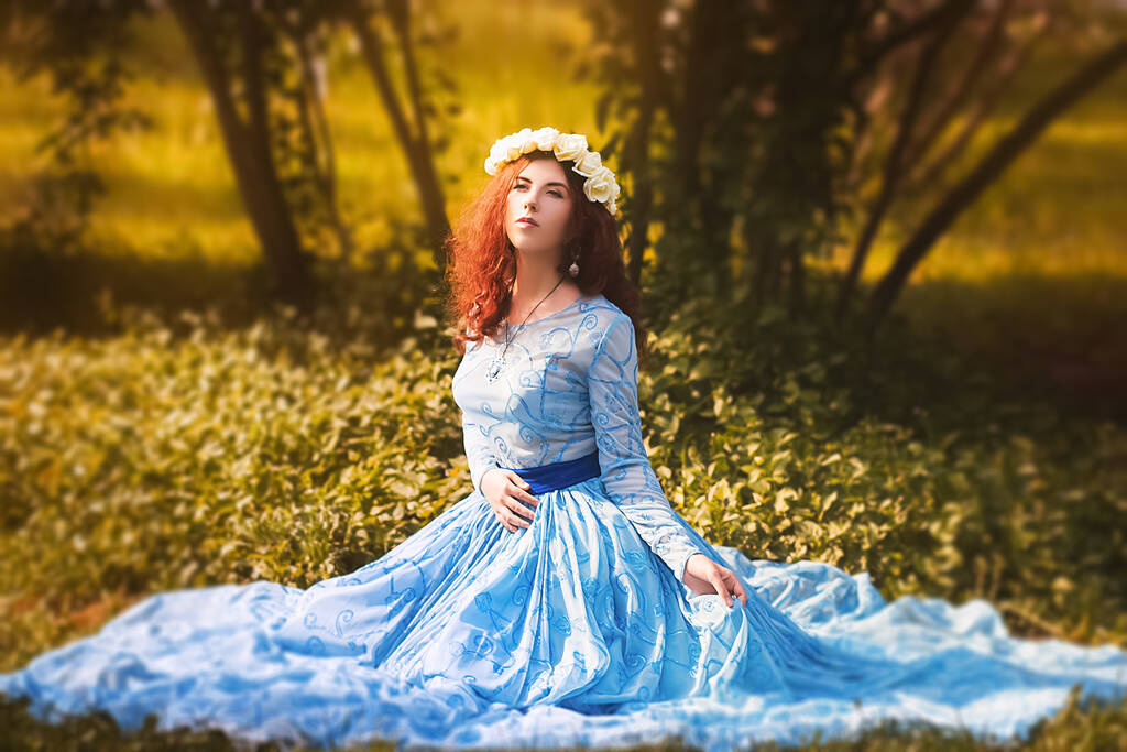 Portré egy vonzó nő peremén fehér virágok és egy kék csodálatos ruhát ül a füvön a parkban hátán orgona bokrok.  - Fotó, kép