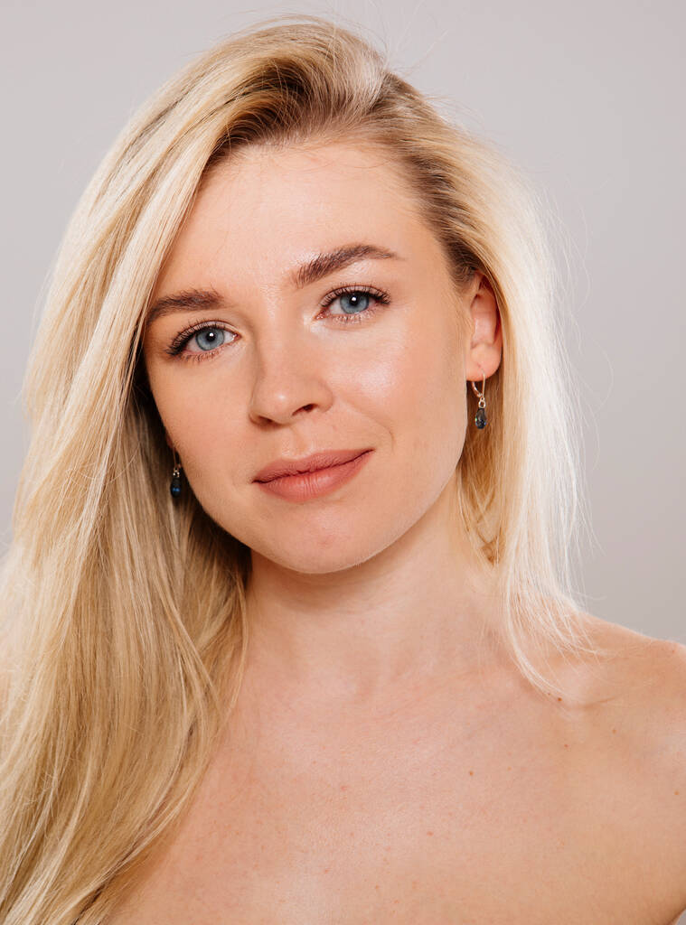 close-up portret van mooie blonde vrouw poseren in studio tegen naakt achtergrond - Foto, afbeelding
