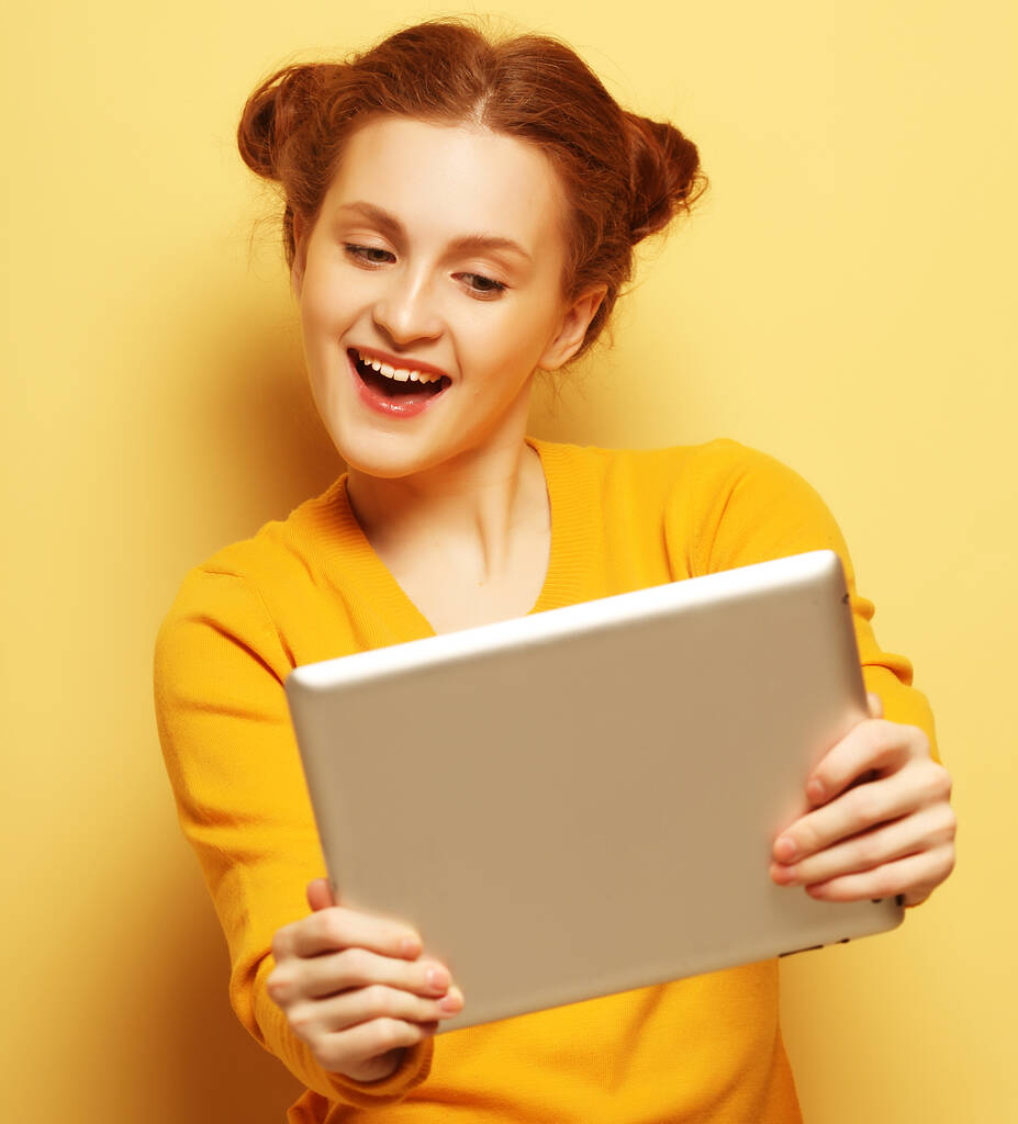 mujer joven con tableta pc sobre fondo amarillo
 - Foto, imagen