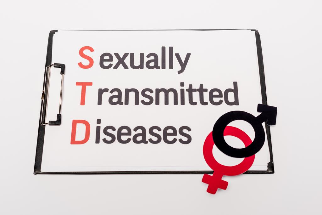 vista superior del portapapeles con enfermedades de transmisión sexual cerca de símbolos de género aislados en blanco
 - Foto, Imagen