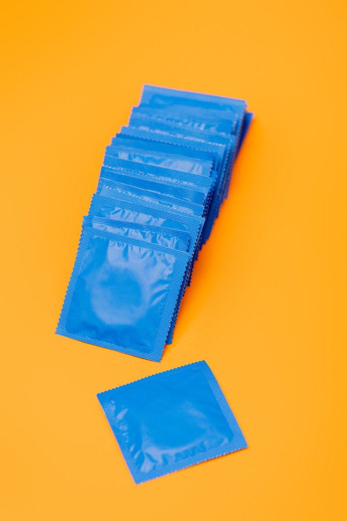 condones en paquetes azules aislados en naranja
  - Foto, imagen