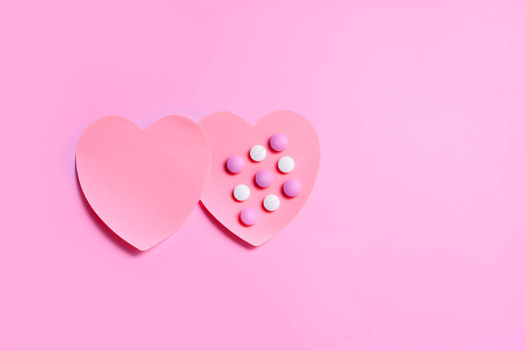 Kaksi kaunista sydäntä, jotka on tehty paperista lähellä toisiaan, toisessa on pillerilääkettä. Terveydenhuolto, ihmiset välittävät käsite Rakkaus
 - Valokuva, kuva