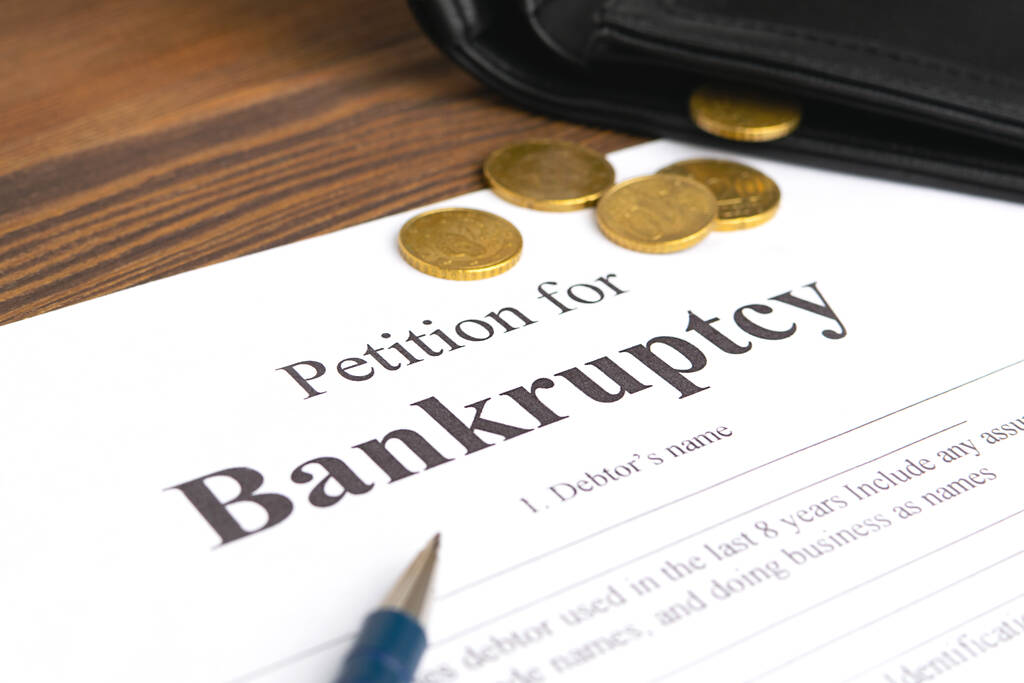 Close-up bancruptcy petitie, pen en gouden munten uit portemonnee. - Foto, afbeelding