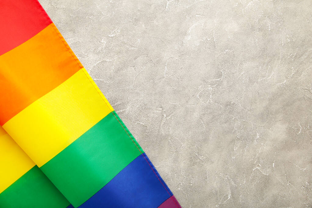 Bandera Rainbow LGBT sobre fondo de hormigón gris, vista superior
 - Foto, Imagen