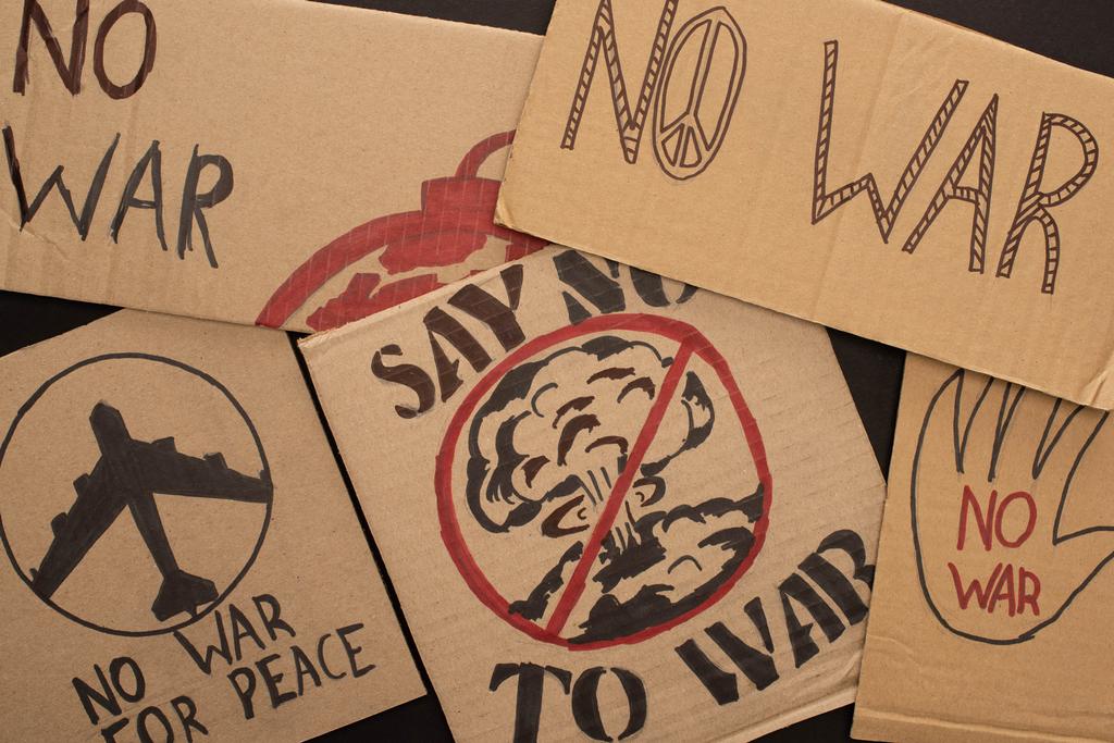 vista superior de carteles de cartón sin letras de guerra y dibujos sobre fondo negro
 - Foto, imagen