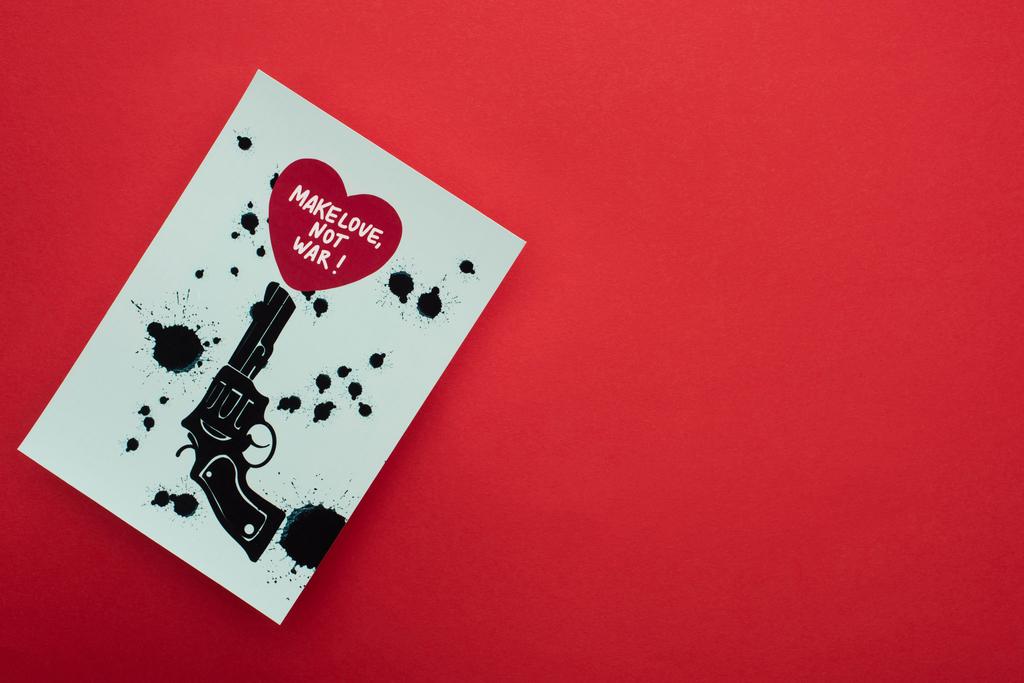 vista superior de papel blanco con revólver negro dibujado y corazón con hacer el amor no letras de guerra sobre fondo rojo
 - Foto, imagen