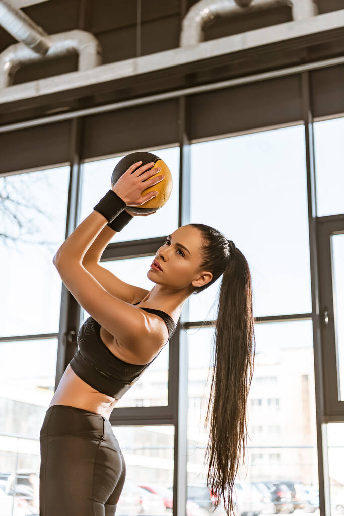 Belle sportive en tenue de sport tenant le ballon dans la salle de gym
 - Photo, image