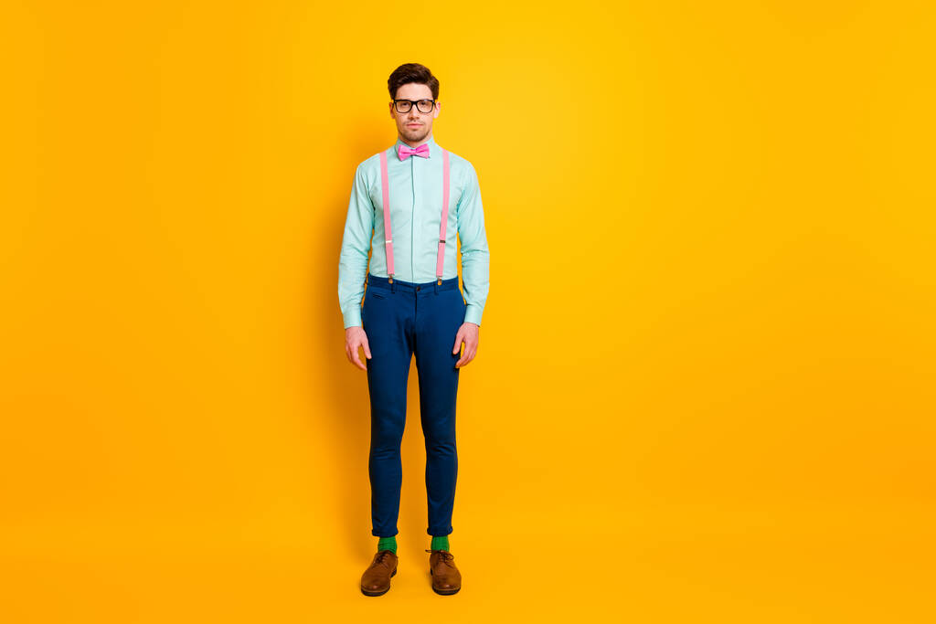 Full length photo of pretty cool clothing guy boy stand self-confidently not smile wear specs shirt τιράντες παπιγιόν παπούτσια κάλτσες απομονωμένες έντονο κίτρινο χρώμα φόντο - Φωτογραφία, εικόνα