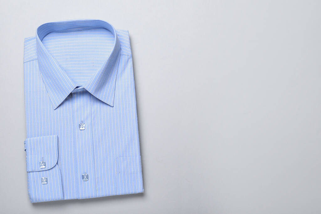 Chemise élégante bleu clair sur fond blanc, vue du dessus avec espace pour le texte. Service de nettoyage à sec
 - Photo, image