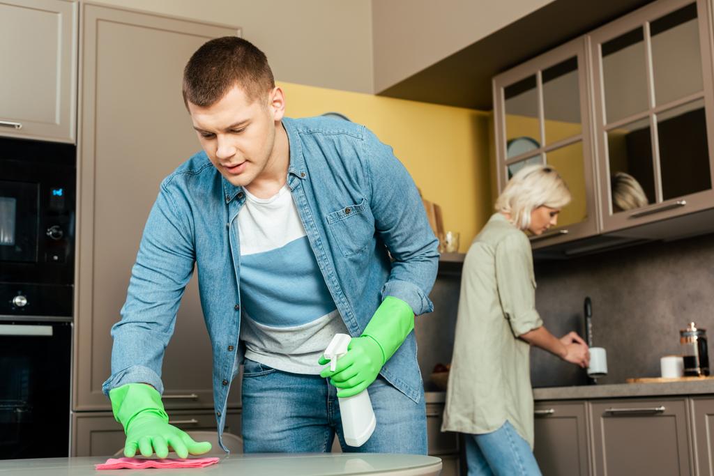 messa a fuoco selettiva del tavolo di pulizia uomo vicino alla donna in cucina a casa
 - Foto, immagini