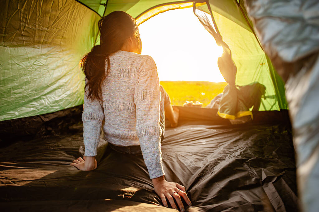 Nainen aasialainen, joka juuri heräsi sisällä teltta katseli auringonnousua aamulla loma toimintaa metsäpolku syyskaudella. Patikointi, patikointi, yksin, metsä, retkeily, toimintakonsepti. - Valokuva, kuva