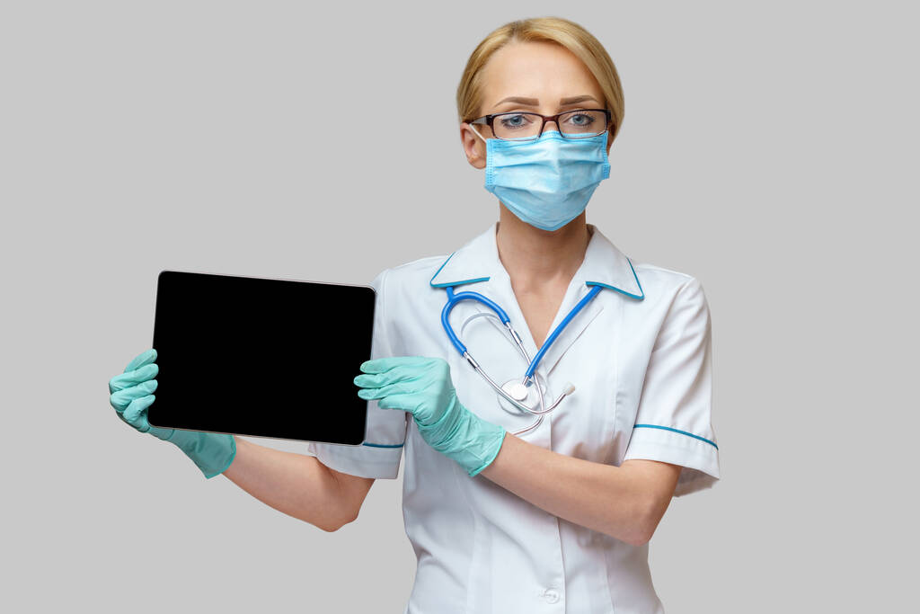 médico médico enfermera mujer con máscara protectora y guantes - la celebración de la tableta de PC
 - Foto, imagen